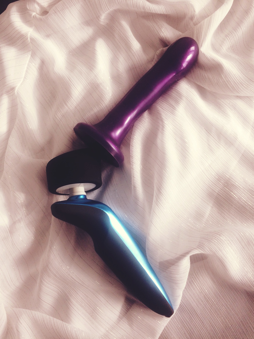 Tantus Rumble blue and black wand vibrator on white background side view showing purple dildo attached to convertible head