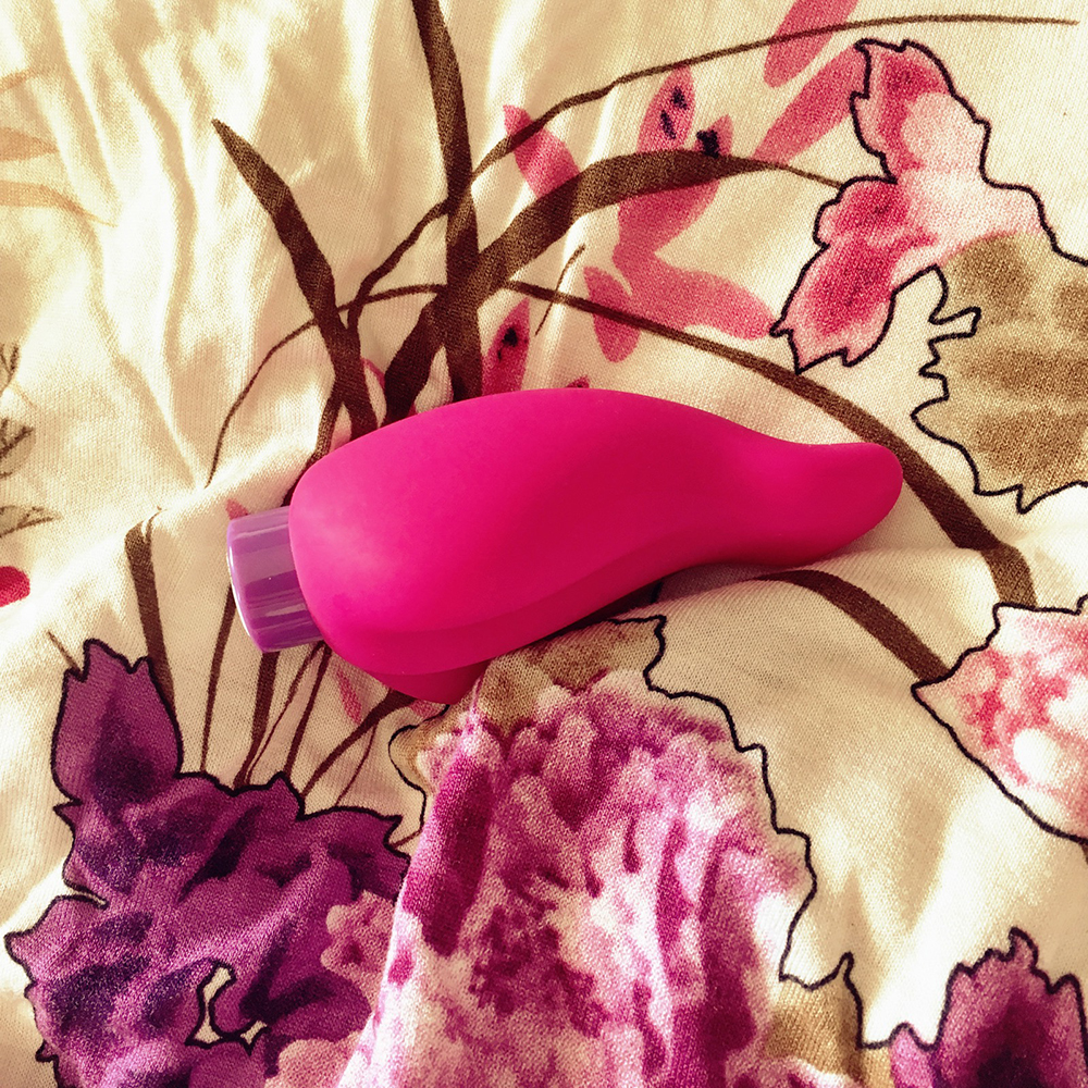 photo of aria hot tongue vibrator - a vaguely tongue shaped pink silicone sheath over purple bullet vibrator