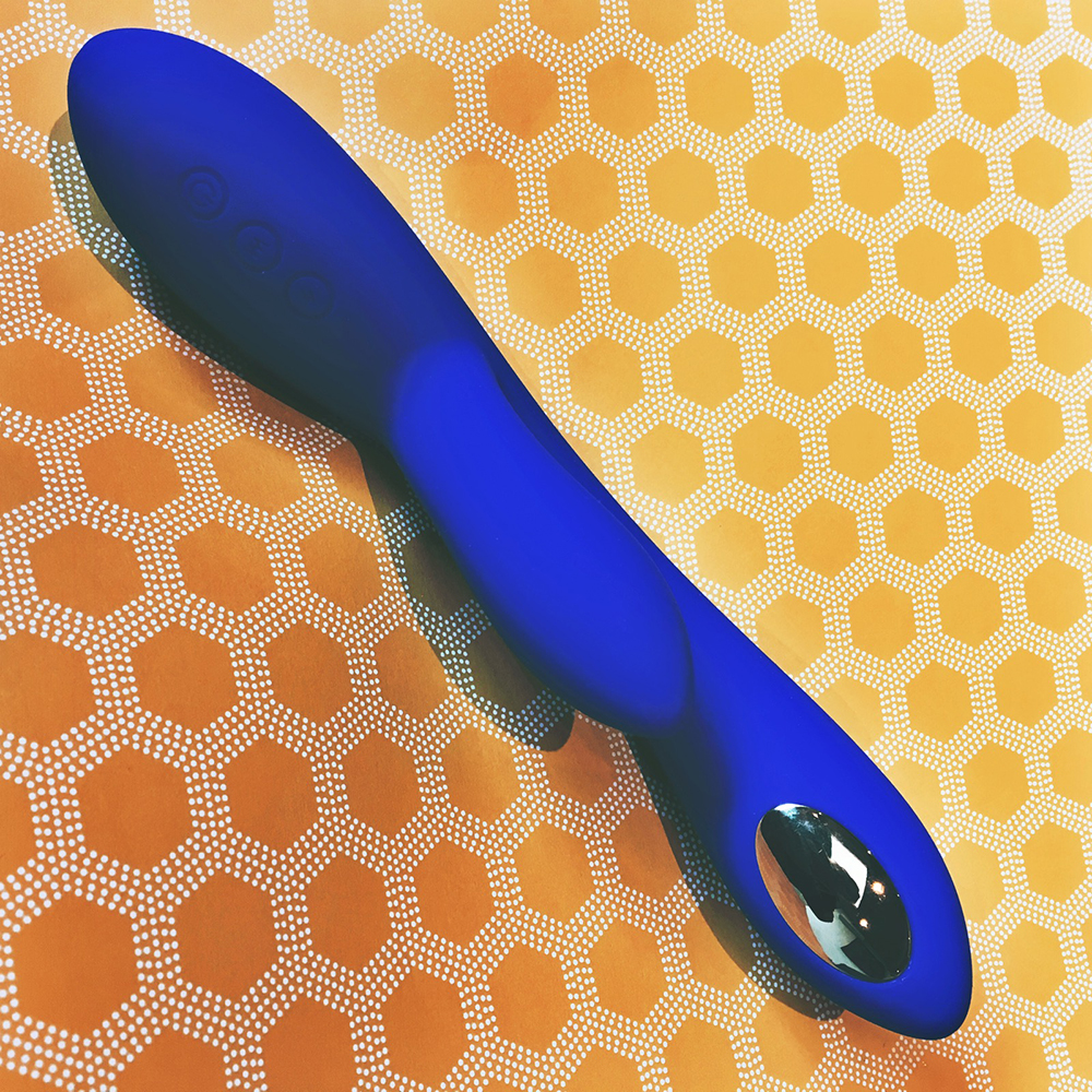 Photo of blue rabbit-style vibrator on yellow heagonal pattern background