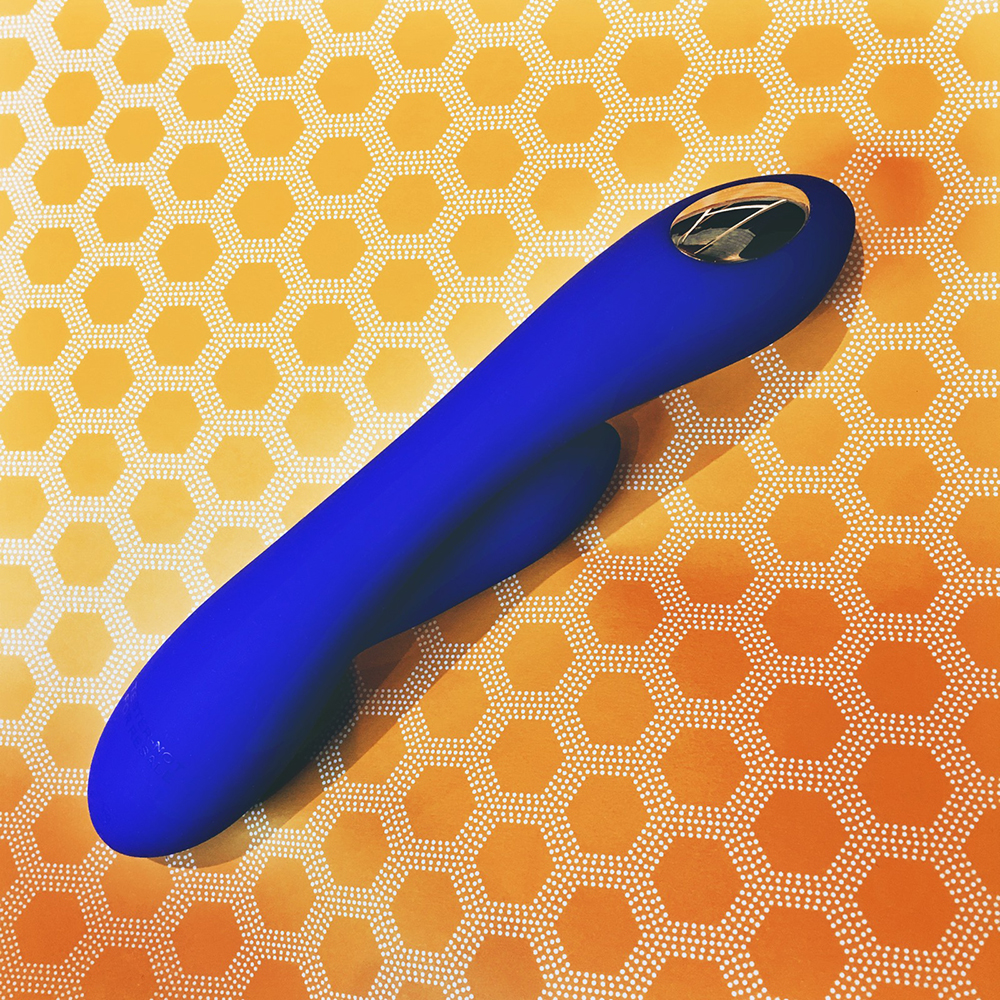 Photo of blue rabbit-style vibrator on yellow heagonal pattern background