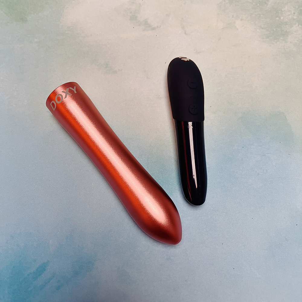 comparison photo of metal doxy bullet vibrator next to we-vibe tango X vibrator. The Doxy is twice as big as the Tango