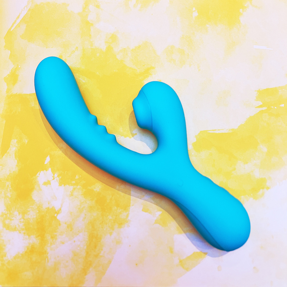 turquoise vibrator turned roughly 45 degrees so that tip of internal arm is pointing very steeply at upper left corner of image, clitoral arm nozzle is now almost parallel with left side of image