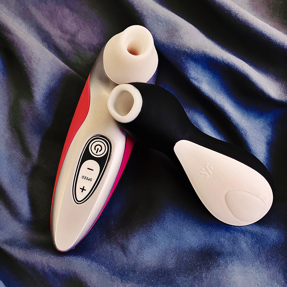 Photograph of silver and pink Womanizer Pro40 and black and white Satisfyer Pro Penguin