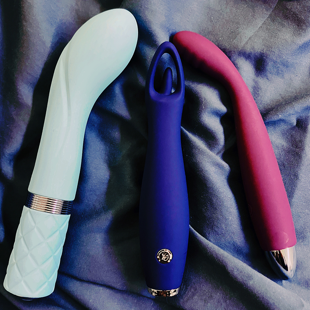 Photograph of three vibrators. Teal G-spot vibe BMS Pillowtalk Sassy on left, blue clit vibe California Exotics Chic Jasmine in middle, purple slim G-spot vibe Svakom CiCi on right