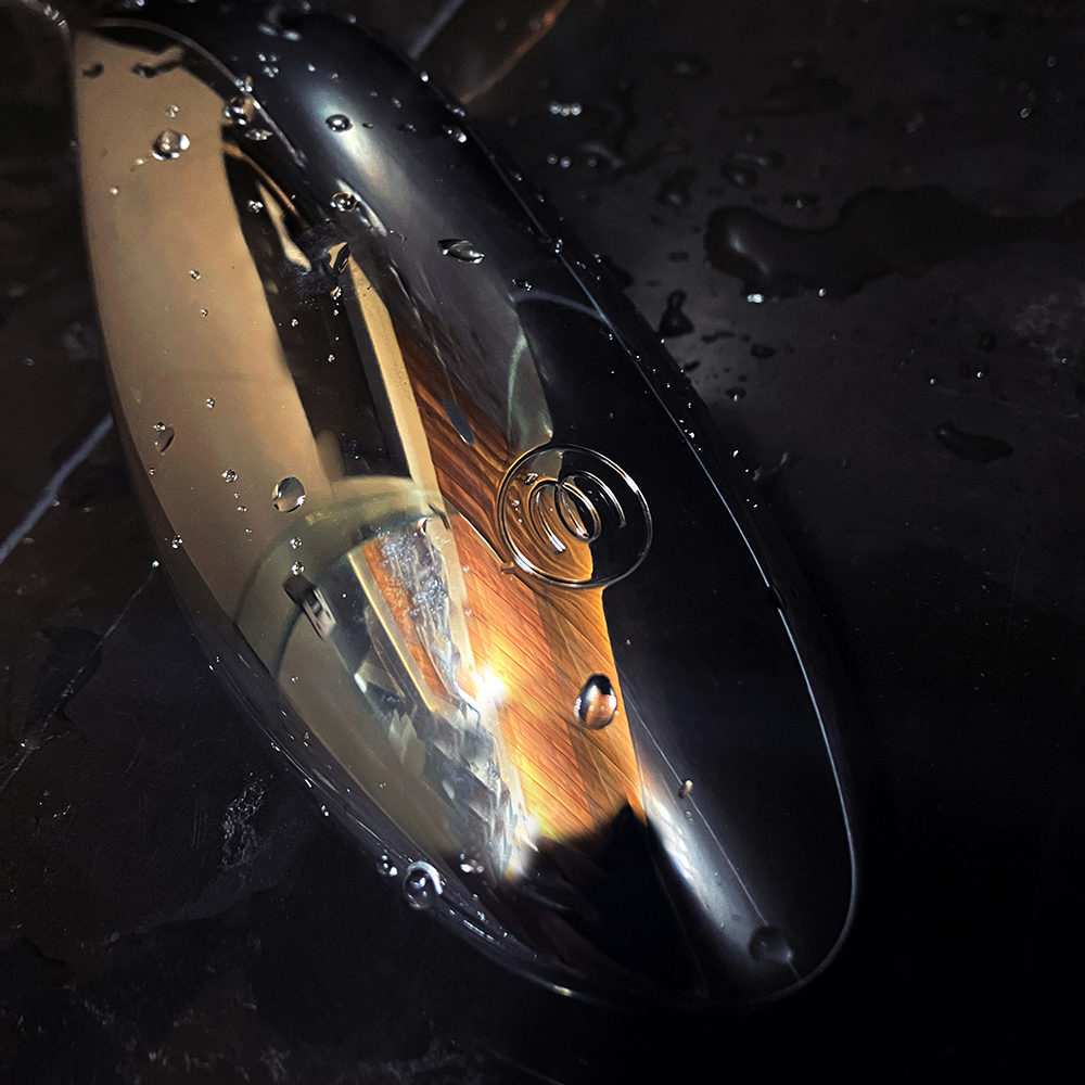 Photograph of the back of a chrome showered with Womanizer logo on it