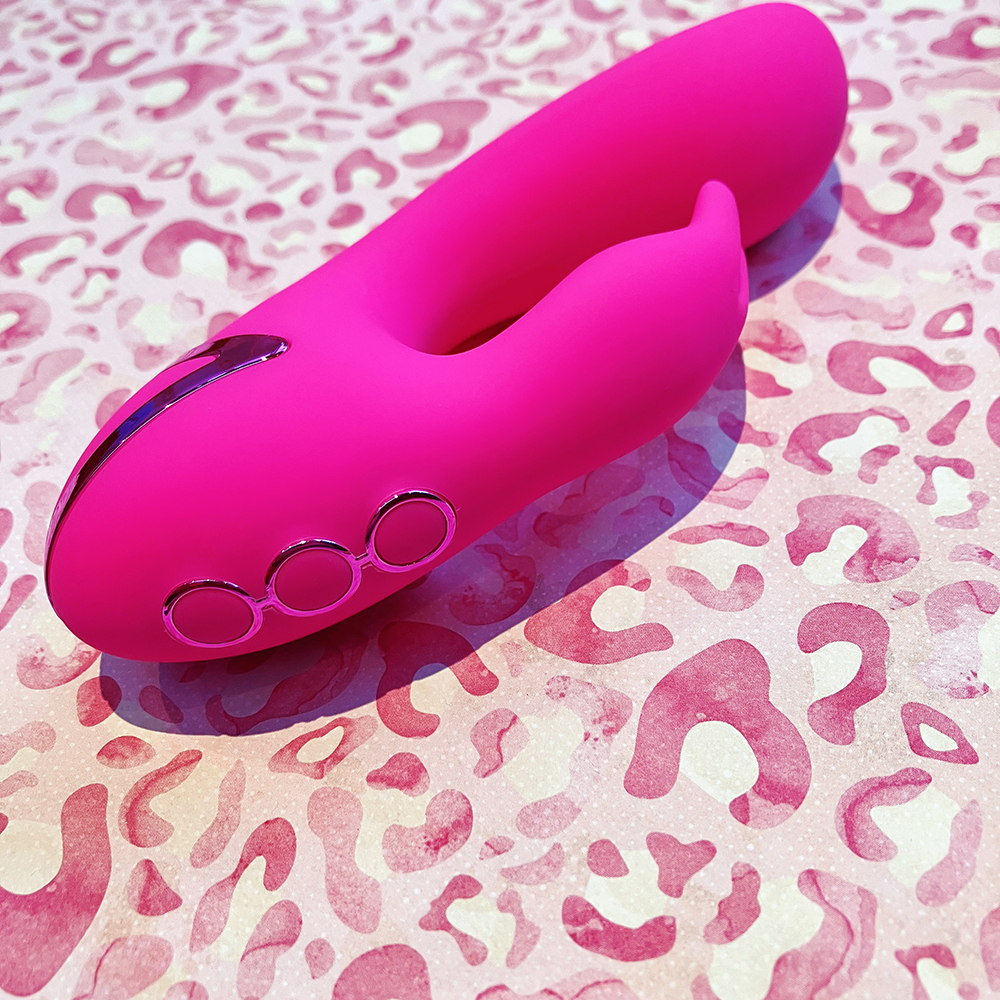 photograph of hot pick U-shaped dual stimulator vibe on its side showing 3 circular buttons at end of the U bend